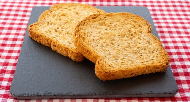 Two slices of toast on a slate plate and tablecloth vintage style